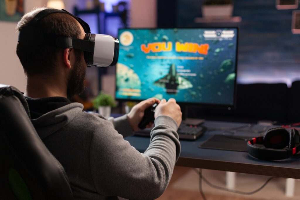 adult using vr goggles to win video games on computer