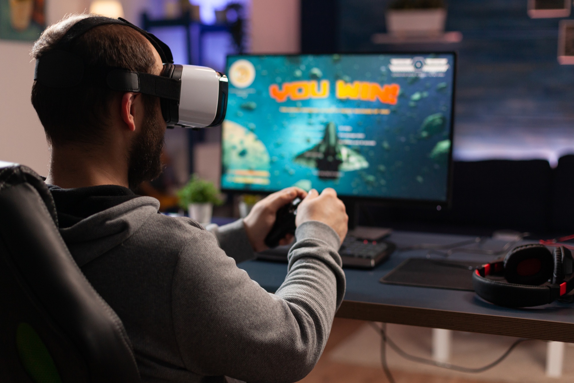 adult using vr goggles to win video games on computer