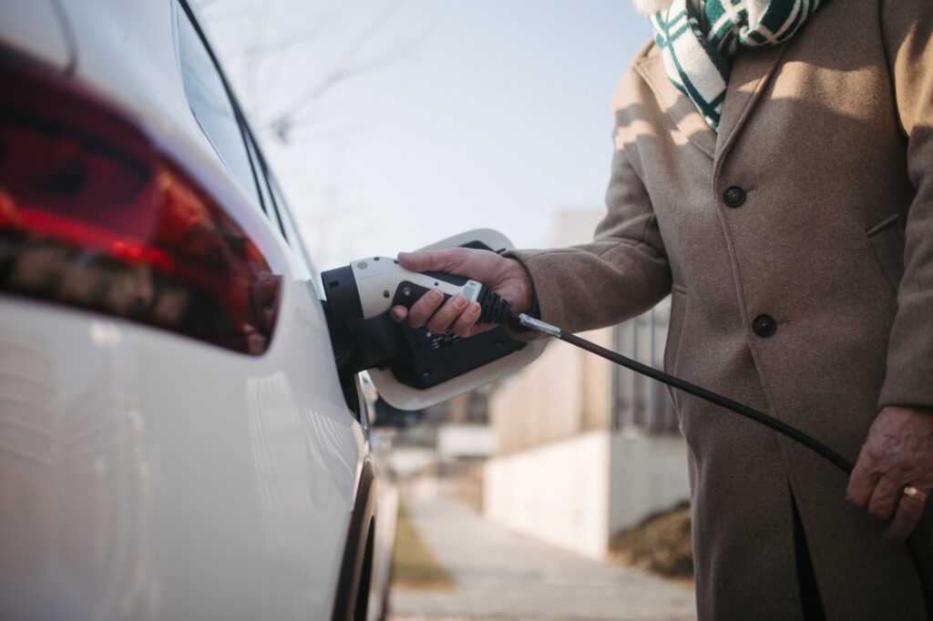 close up of senior man charging electric car