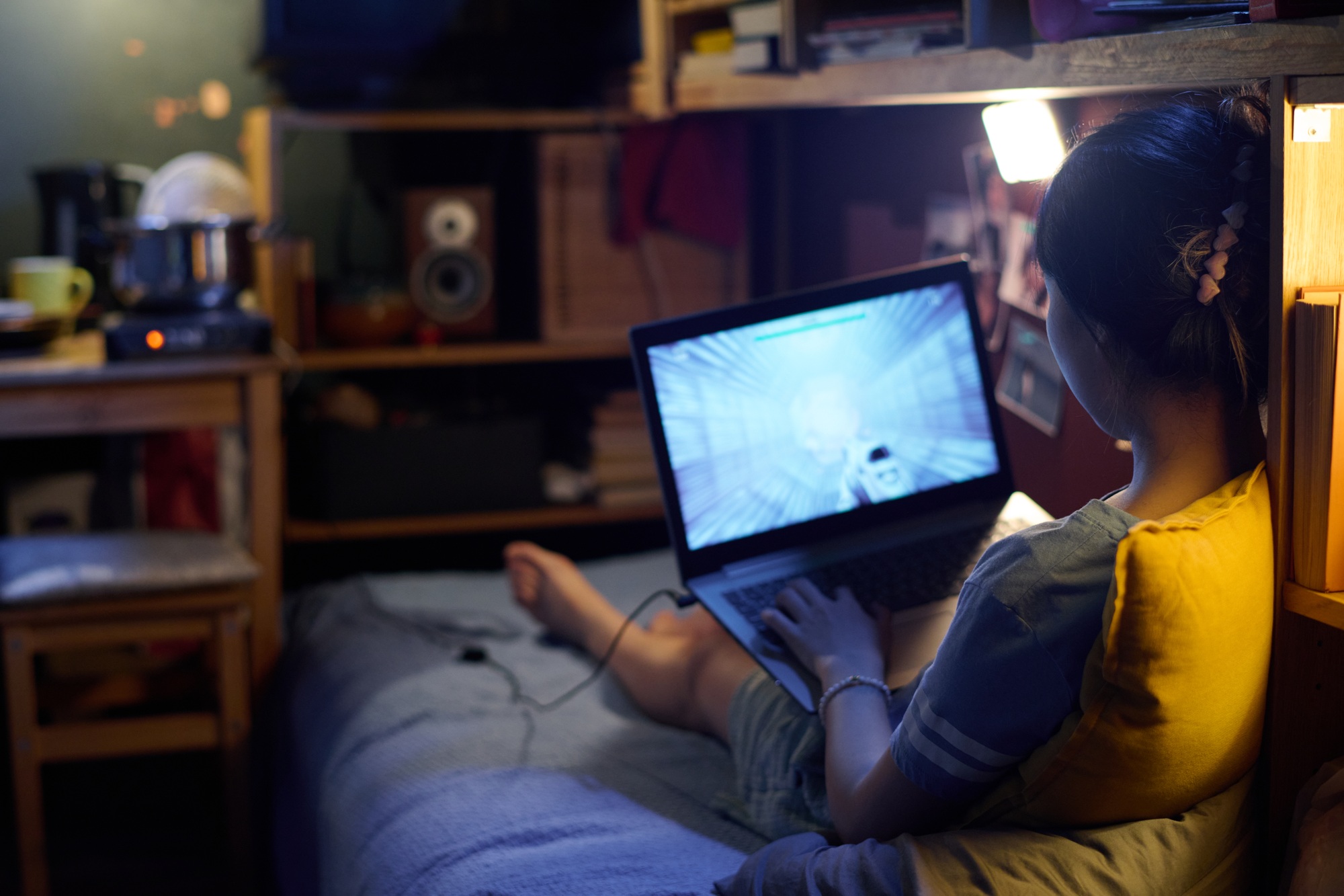 girl playing computer game at home